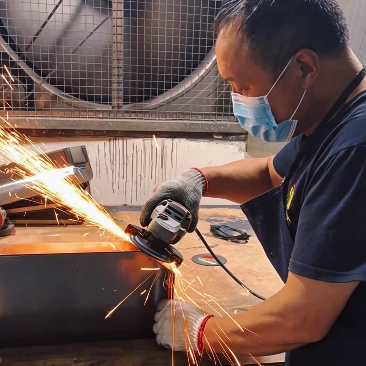 Fabex operator polishing a fabricated metal enclosure